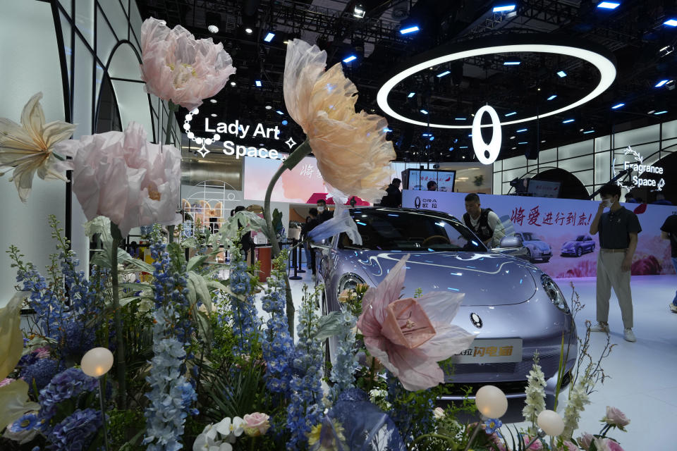 Floral decorations frame a car from Ora, a Chinese electric car brand during the Auto Shanghai 2023 show at the National Exhibition and Convention Center in Shanghai, China, Tuesday, April 18, 2023. Global and Chinese automakers plan to unveil more than a dozen new electric SUVs, sedans and muscle cars this week at the Shanghai auto show, their first full-scale sales event in four years in a market that has become a workshop for developing electrics, self-driving cars and other technology. (AP Photo/Ng Han Guan)