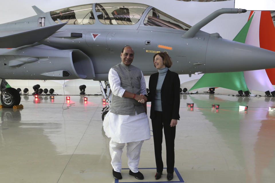 Indian defense Minister Rajnath Singh shakes hands with French Defense Minister Florence Parly at the Dassault Aviation plant in Merignac, near Bordeaux, southwestern France, Tuesday, Oct. 8, 2019. Rajnath Singh formally accepted the first Rafale fighter jet after India had signed a deal with the French government and Dassault Aviation in September 2016, to acquire 36 Rafale fighter jets. (AP Photo/Bob Edme)