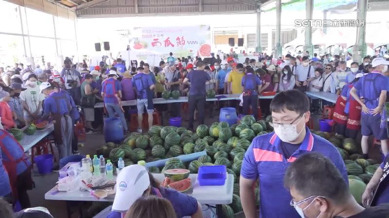 工作檯前擠滿等著吃西瓜的民眾。