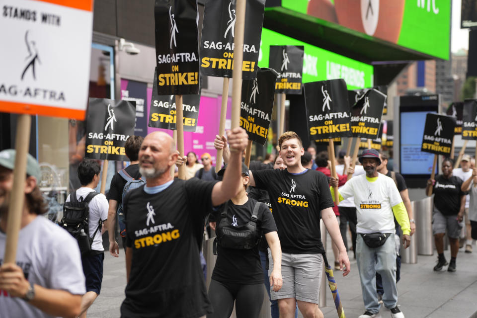Picketers carry signs outside Paramount in Times Square on Friday, July 21, 2023, in New York. 