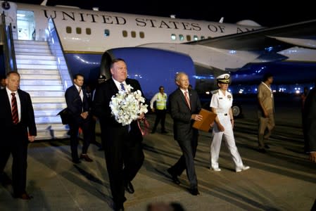 U.S Secretary of State Mike Pompeo holds flowers he received on arrival to New Delhi