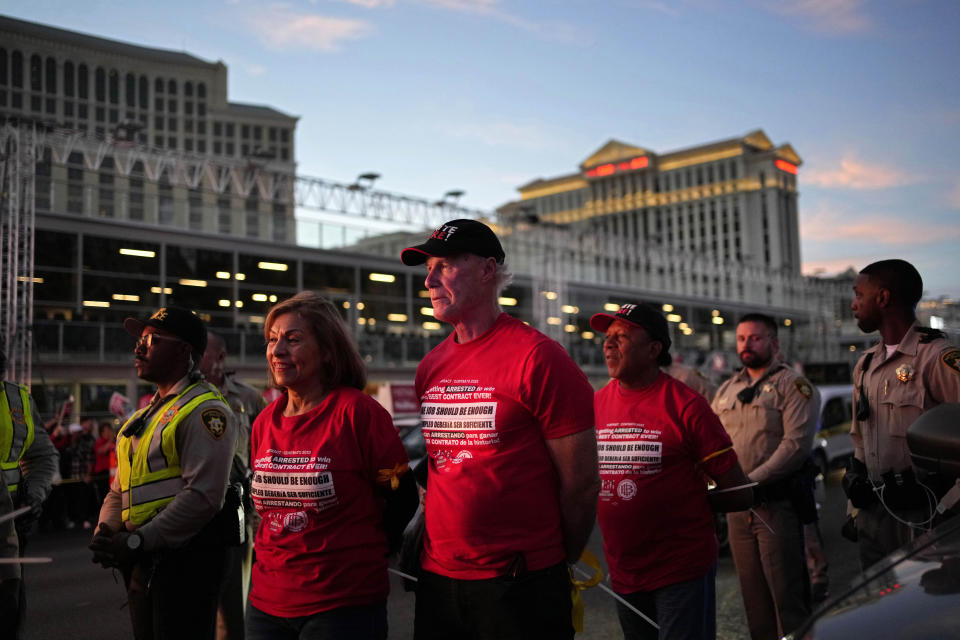 Geoconda Arguello-Kline, left, former Secretary-Treasurer of the Culinary Workers Union and D. Taylor, center, president of Unite Here, are arrested by Las Vegas police along the Strip, Wednesday, Oct. 25, 2023, in Las Vegas. Thousands of hotel workers fighting for new union contracts rallied Wednesday night on the Las Vegas Strip, where rush-hour traffic was disrupted when some members blocked the road before being detained by police. (AP Photo/John Locher)