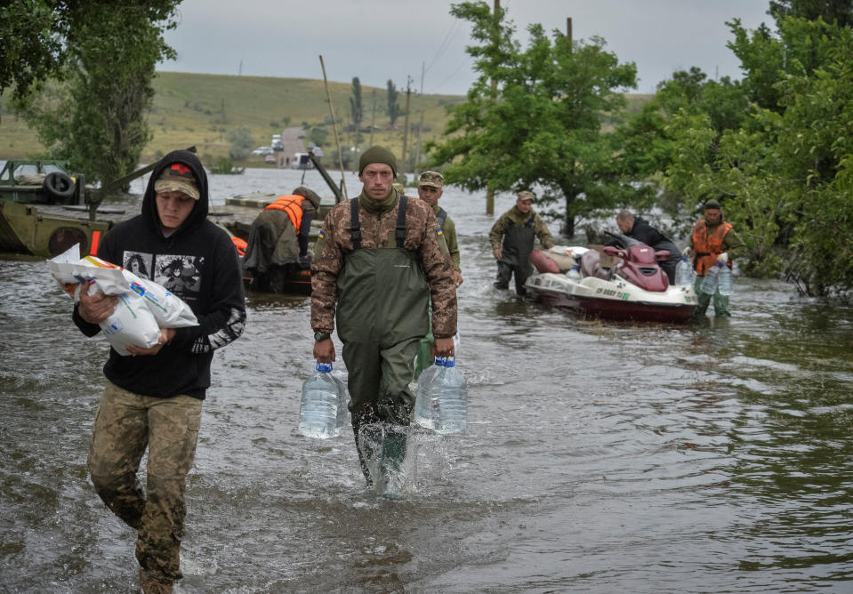 Ukrainian servicemen unload humanitarian aid for local residents, amid Russia's attack on Ukraine, after the Nova Kakhovka dam breached, in the flooded village of Afanasiivka in Kherson region, Ukraine June 12, 2023. REUTERS/Oleksandr Klymenko