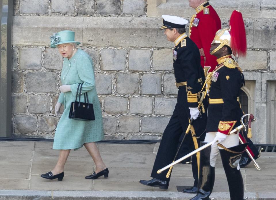 The queen is accompanied to the viewing platform.