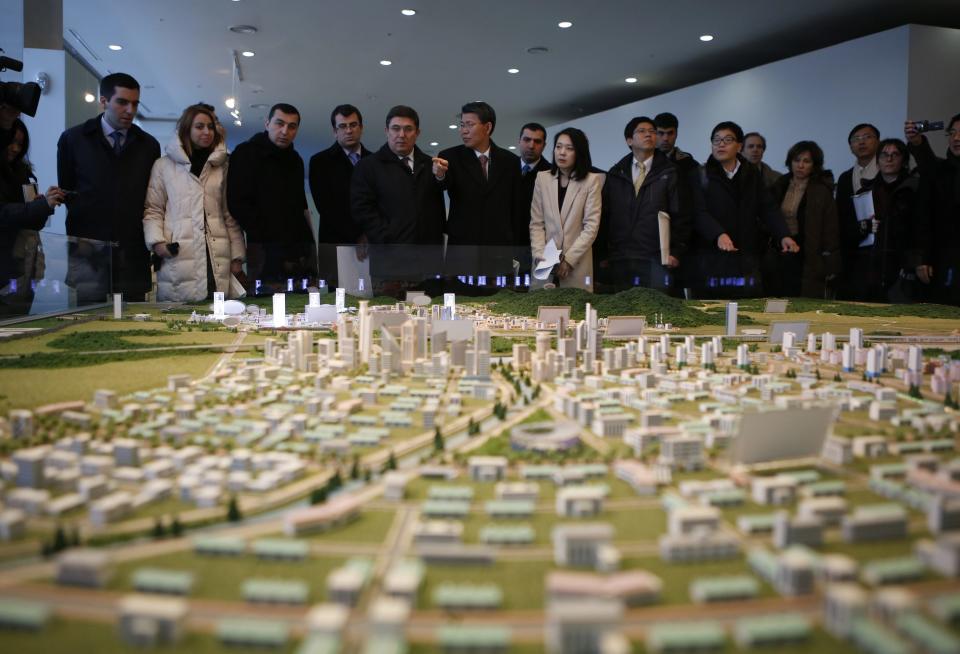 Officials from the G20 Seoul Conference look at miniature models of the Kaesong Industrial Complex (KIC) in Kaesong