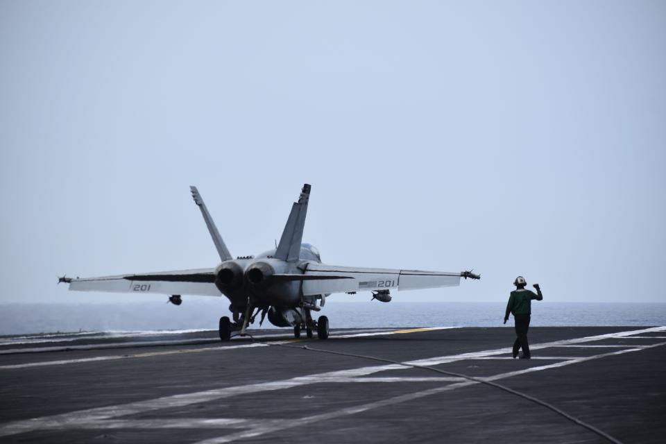 A fighter jet lands on the deck of the USS Dwight D. Eisenhower.