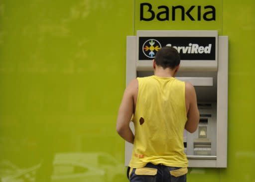 A man uses a Bankia ATM machine n Madrid. Spain has charged two global consulting firms, Roland Berger and Oliver Wyman, with valuing the battered banking system's deeply troubled balance sheets