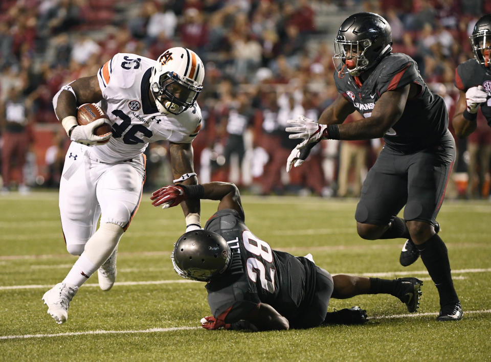 Auburn running back Kamryn Pettway (36) slips past Arkansas defenders Josh Liddell (28) and De’Jon Harris (8) as he runs for a touchdown during the second half of an NCAA college football game in Fayetteville, Ark., Saturday, Oct. 21, 2017. (AP Photo/Michael Woods)