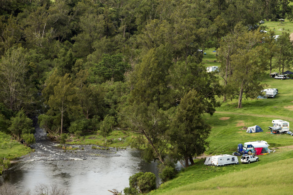 Caravans and tents seen by a river in NSW. 