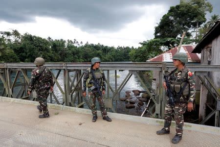 Philippines army soldiers guard a bridge during an operation to retrieve bodies of casualties from the fighting zone in Marawi City, Philippines June 28, 2017. REUTERS/Jorge Silva