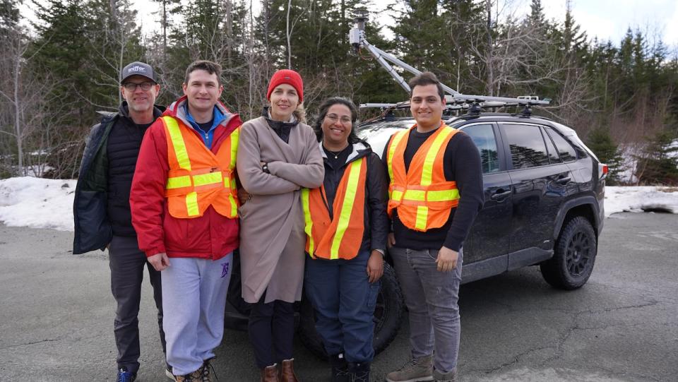 Members of the St. Francis Xavier Flux Lab stand in front of their mobile laboratory, with measuring equipment attached to the car roof. From left to right: Dave Risk, Yurii Dudak, Chelsie Hall, Nadia Tarakki, and Amirali Foomajd.