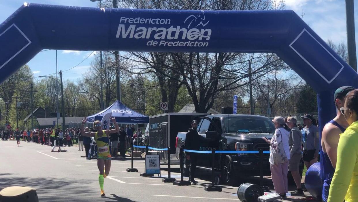 Sarah Mulcahy waves and smiles while finishing the Fredericton Marathon with a course record. (Sam Farley/CBC - image credit)