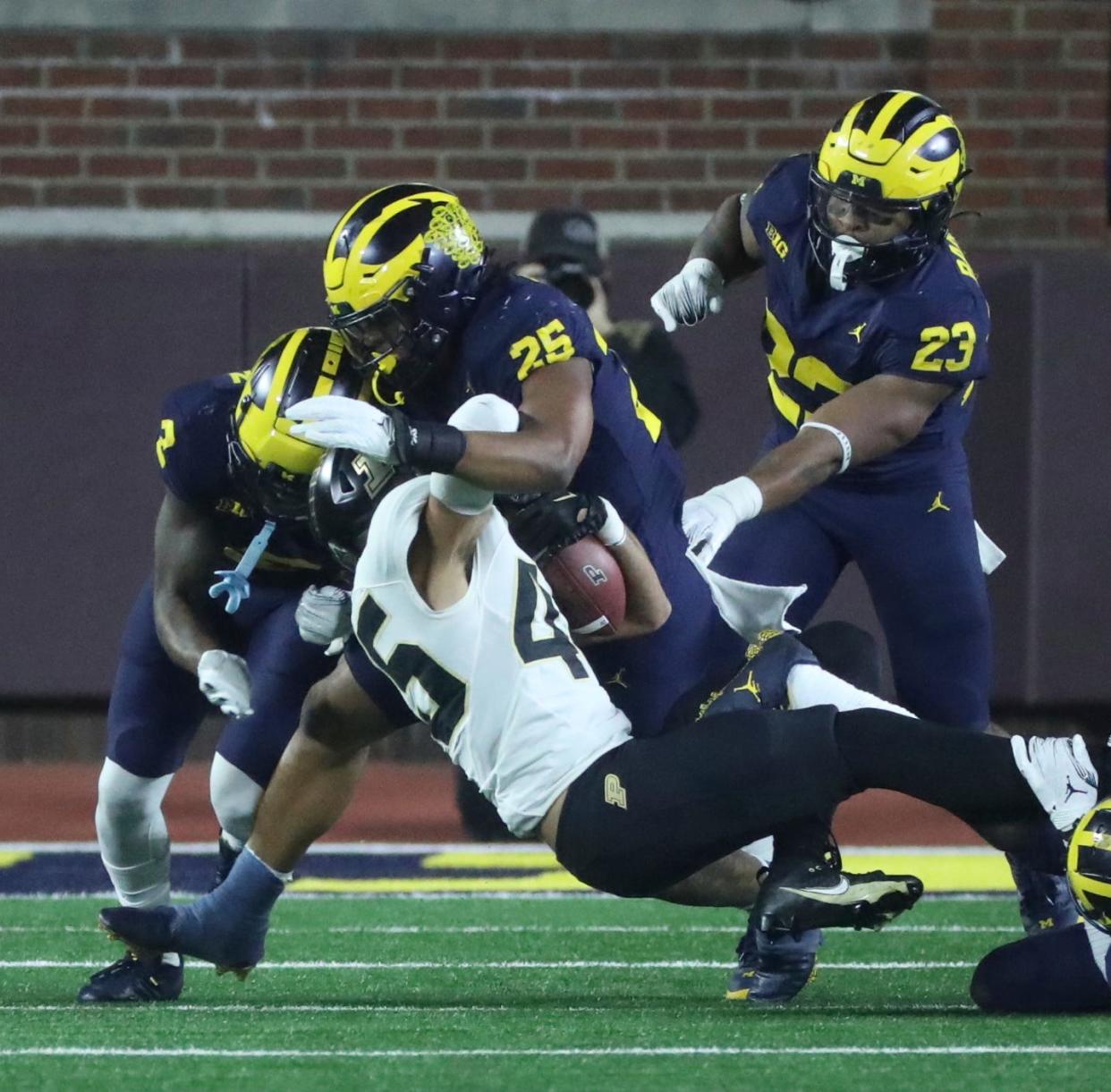 Michigan Wolverines linebacker Junior Colson (25) tackles Purdue Boilermakers running back Devin Mockobee (45) during the first half at Michigan Stadium, Saturday, Nov. 4, 2023.