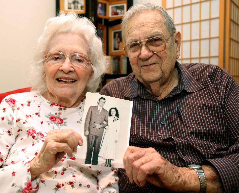 This 2018 file photo shows Bob and Betty Ward, both 92 at the time, holding a picture from their wedding day in 1948 as they prepared to celebrate their 70th anniversary.