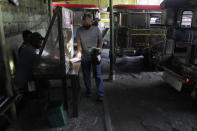 FILE - A man shows his vaccination card before riding a passenger jeep at a terminal in Quezon city, Philippines on Jan. 17, 2022. As the omicron variant is making its latest appearance, officials in the Philippines started banning commuters who have not been fully vaccinated from riding public transportation in greater Manila, a region of more than 13 million people. (AP Photo/Aaron Favila, File)