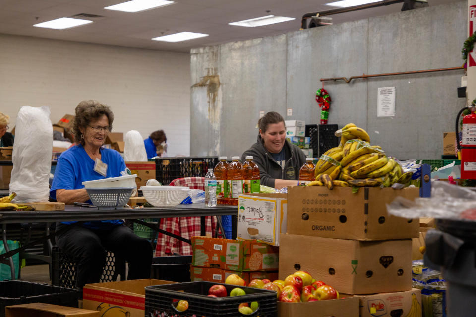 Volunteers at Valley View Community Food Bank help to assemble food boxes for families on Dec. 18, 2023, in Sun City.