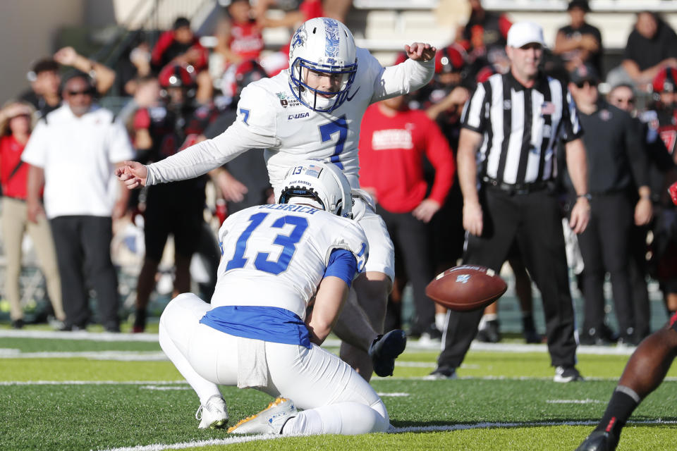 Middle Tennessee punter Kyle Ulbrich (13) holds as placekicker Zeke Rankin (7) makes an extra point against San Diego State during the first half of the Hawaii Bowl NCAA college football game, Saturday, Dec. 24, 2022, in Honolulu. (AP Photo/Marco Garcia)