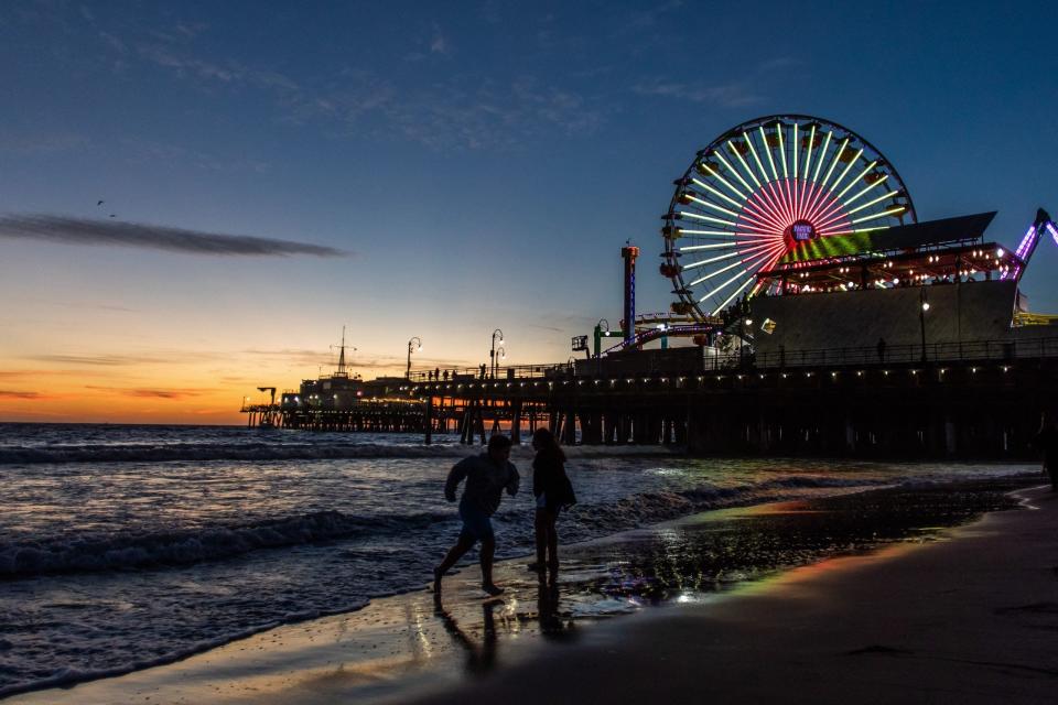 The Santa Monica Pier is pictured as the sun sets in Santa Monica, California. Photo by Apu GOMES / AFP