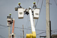 <p>A brigade from the Electric Power Authority repairs distribution lines damaged by Hurricane Maria in the Cantera community of San Juan, Puerto Rico on Oct. 19, 2017. The storm struck after the Authority had filed for bankruptcy in July, put off maintenance and had finished dealing with outages from Hurricane Irma. (Photo: Carlos Giusti/AP) </p>