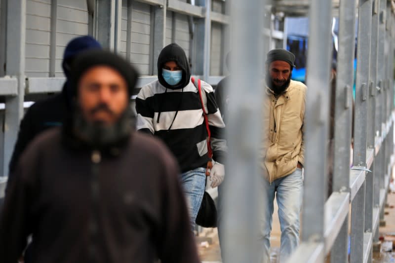 Palestinians working in Israel head to work through an Israeli checkpoint, near Hebron in the Israeli-occupied West Bank