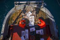 Francesco Di Bartolomeo, left, and Francesco select fish quality aboard Marianna, during a fishing trip in the Tyrrhenian Sea, early Thursday morning, April 2, 2020. Italy’s fishermen still go out to sea at night, but not as frequently in recent weeks since demand is down amid the country's devastating coronavirus outbreak. For one night, the Associated Press followed Pasquale Di Bartolomeo and his crew consisting of his brother Francesco and another fishermen, also called Francesco, on their trawler Marianna. (AP Photo/Andrew Medichini)