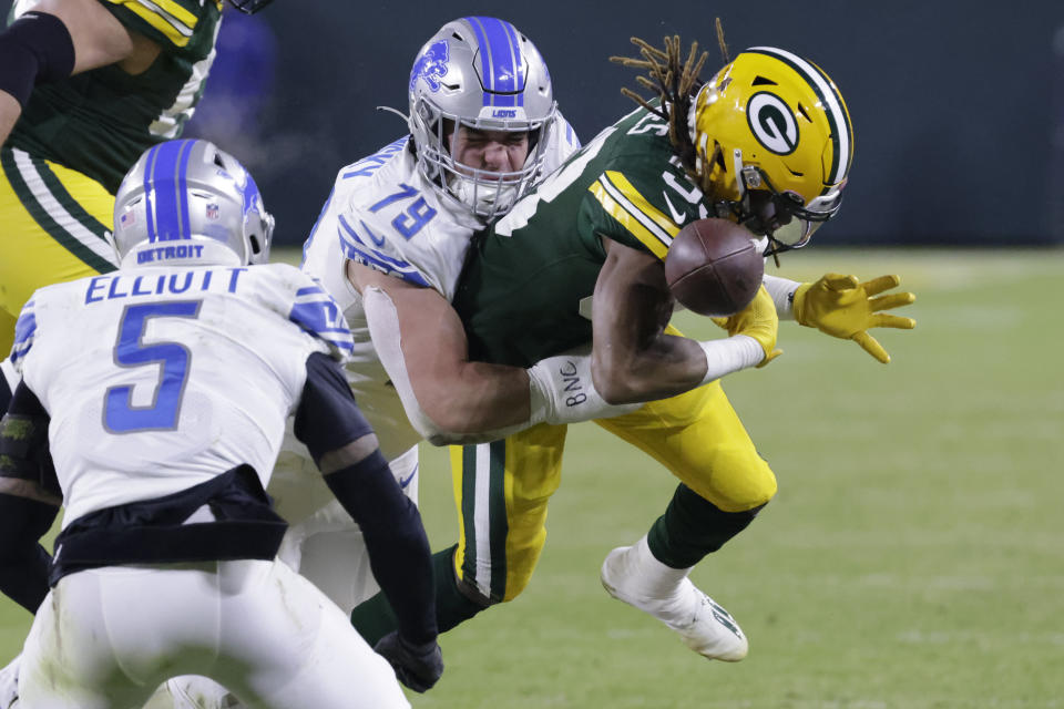 Green Bay Packers running back Aaron Jones fumbles as he is hit by Detroit Lions defensive end John Cominsky (79) during the first half of an NFL football game Sunday, Jan. 8, 2023, in Green Bay, Wis. The Lions recovered the fumble. (AP Photo/Mike Roemer)