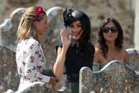 <p>Meghan giving a wave. <a rel="nofollow noopener" href="https://www.townandcountrymag.com/style/fashion-trends/a22639732/meghan-markle-colorful-navy-dress-charlie-van-straubenzee-wedding/" target="_blank" data-ylk="slk:Get all the details on her outfit, including that Philip Treacy fascinator, right here.;elm:context_link;itc:0;sec:content-canvas" class="link ">Get all the details on her outfit, including that Philip Treacy fascinator, right here.</a></p>