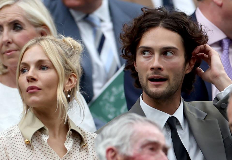 Sienna Miller and Oli Green sit in the royal box for day nine of Wimbledon (EPA)