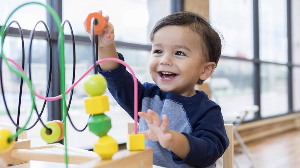 toddler playing with bead maze