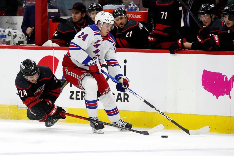 New York Rangers’ Kaapo Kakko (24) and Carolina Hurricanes’ Seth Jarvis (24) battle for the puck during the third period of Game 2 of an NHL hockey Stanley Cup second-round playoff series in Raleigh, N.C., Friday, May 20, 2022.