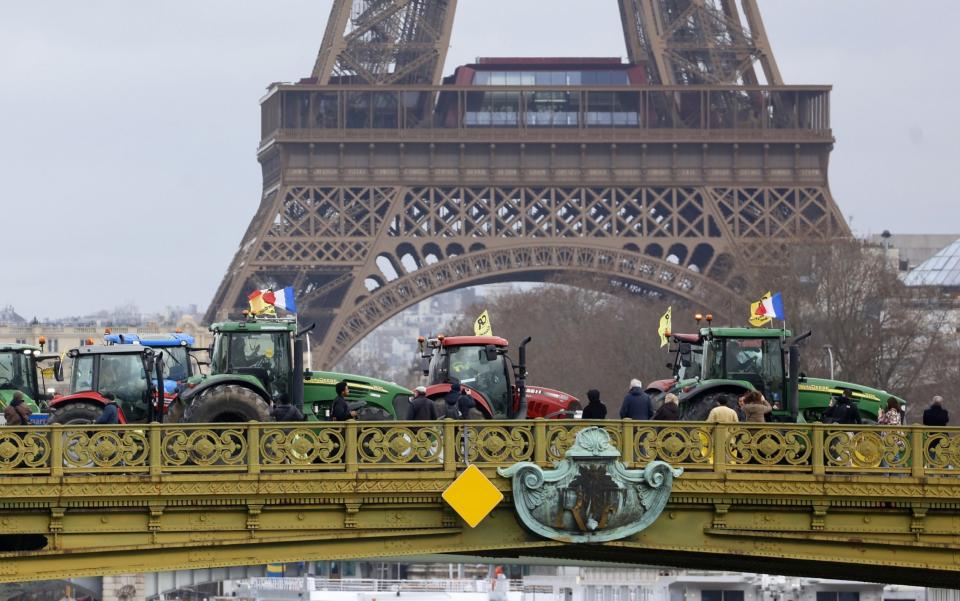 Farmers protesting EU regulations parked their tractors on the Pont Mirabeau today in front of the Eiffel Tower, which has been shut since Monday as part of separate industrial action