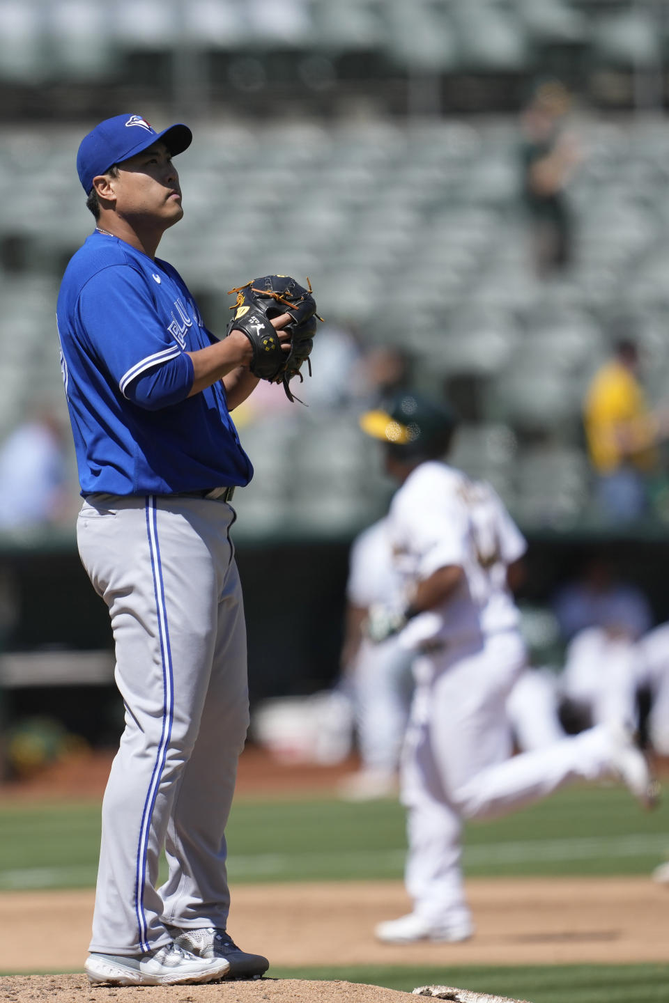 Toronto Blue Jays pitcher Hyun Jin Ryu, left, reacts after allowing a two-run home run to Oakland Athletics' Carlos Perez, rear, during the fourth inning of a baseball game in Oakland, Calif., Wednesday, Sept. 6, 2023. (AP Photo/Jeff Chiu)