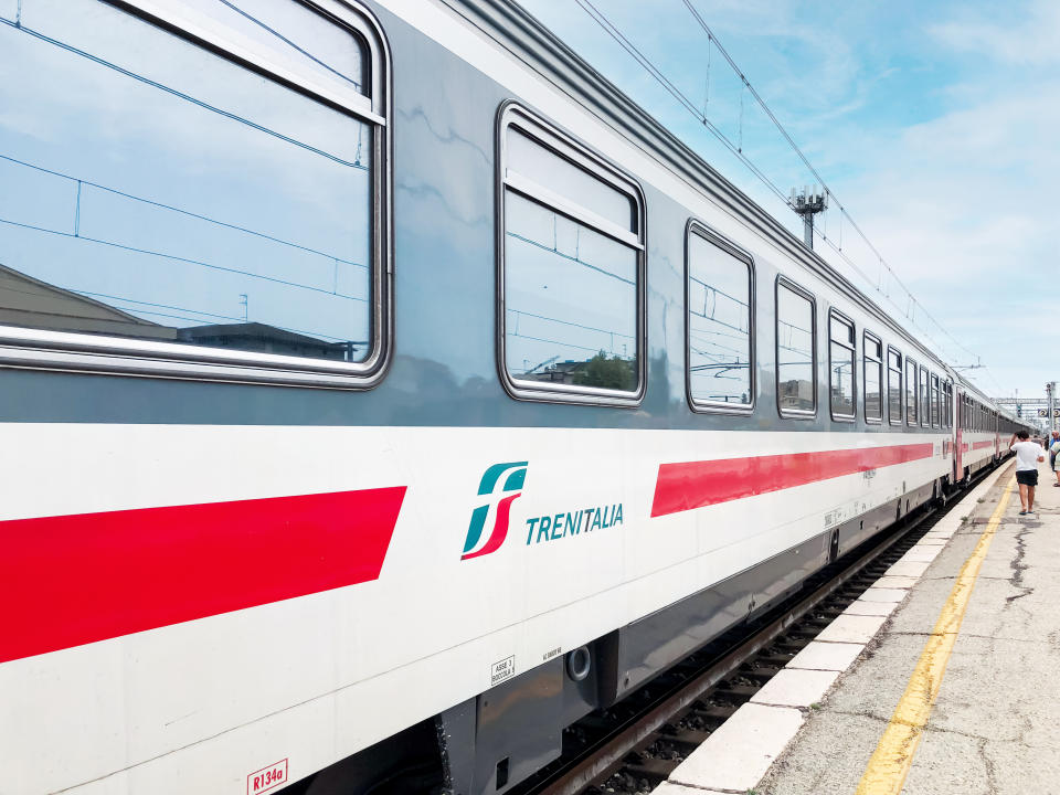 a trenitalia train waiting at a stop