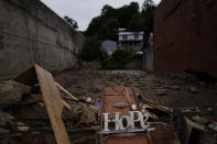 A "hope" sign sits atop a pile of debris on Friday, Aug. 5, 2022, after massive flooding the previous week in Fleming-Neon, Ky. (AP Photo/Brynn Anderson)