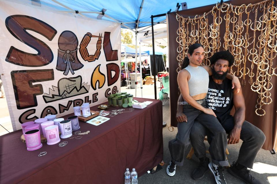 DeMarkus Trinidad-Williams, left, and his husband, Ko Trinidad-Williams, sell candles.