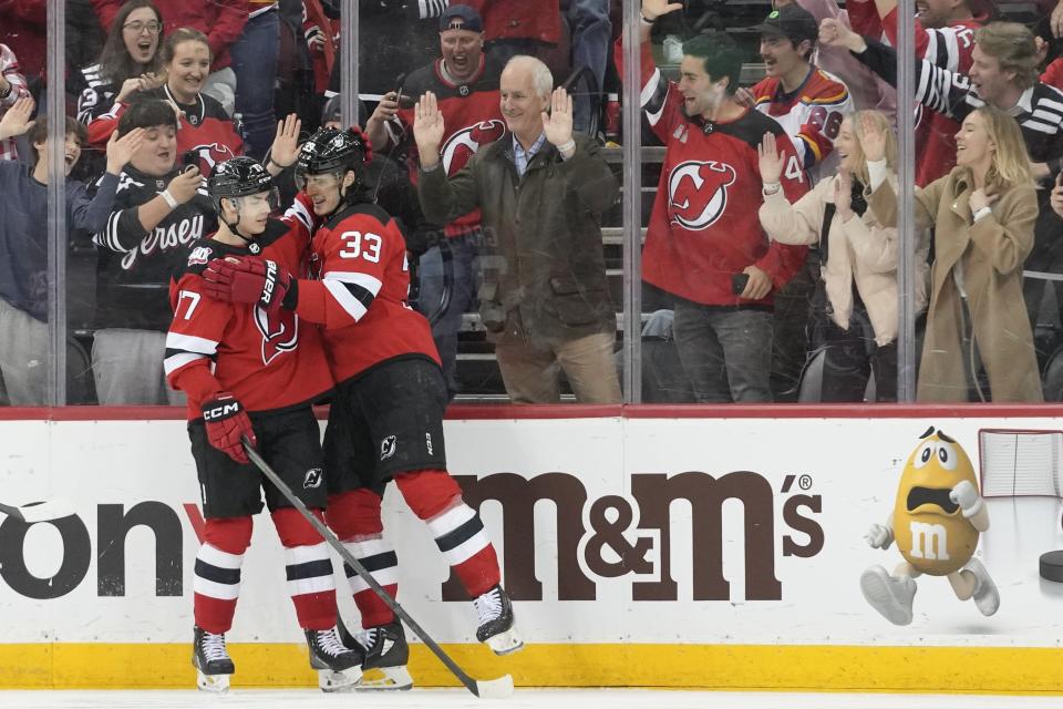 New Jersey Devils defenseman Ryan Graves (33) celebrates his goal against the Columbus Blue Jackets with center Yegor Sharangovich (17) during the third period of an NHL hockey game Thursday, April 6, 2023, in Newark, N.J. The Devils won 8-1. (AP Photo/Mary Altaffer)