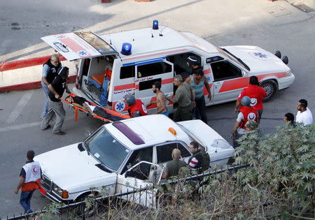 Medics transport an injured man, after clashes between Fatah fighters and Islamists in Ain al-Hilweh Palestinian refugee camp, near the port-city of Sidon, southern Lebanon, August 25, 2015. REUTERS/Ali Hashisho