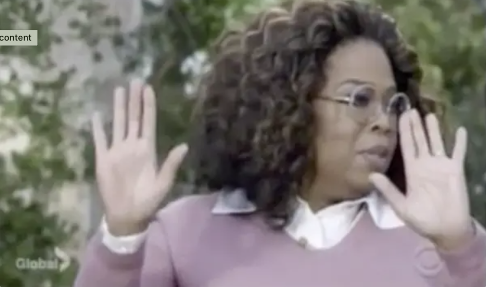Oprah putting her hands up in an interview