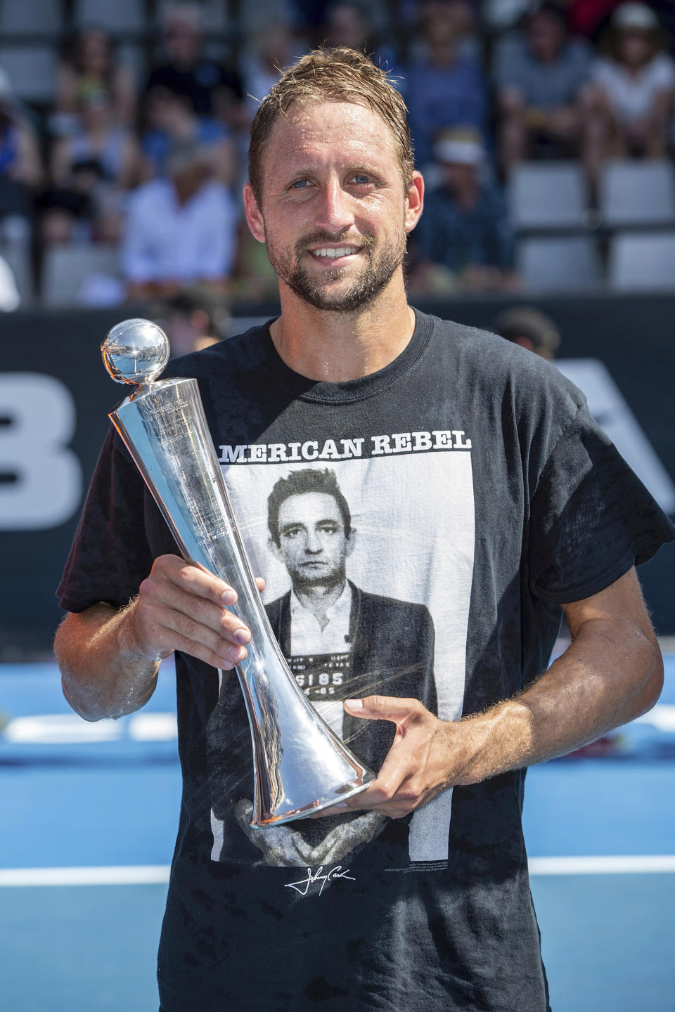 Tennys Sandgren of the U.S. celebrates with the trophy after defeating Britain's Cameron Norrie in their singles final match in the ASB Classic at ASB Tennis Arena in Auckland, New Zealand, Saturday, Jan. 12, 2019. (AP Photo/David Rowland)