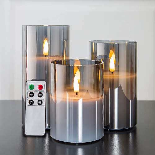 3 glass flameless candles with remote sitting on table