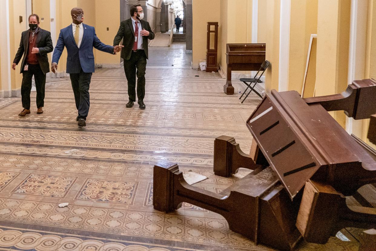 <p>Senator Tim Scott, second from left, walks past damage in the early morning hours after protesters stormed the Capitol in Washington</p> (AP)