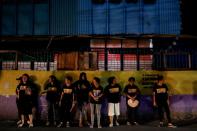 Members of a volunteer group of women take a break while patrolling with police officers on the streets of Pateros