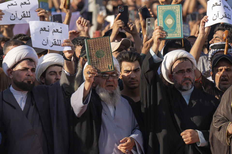 Supporters of the Shiite cleric Muqtada al-Sadr raises the Quran, the Muslims' holy book, during a demonstration in front of the Swedish embassy in Baghdad in response to the burning of Quran in Sweden, Baghdad, Iraq, Friday, June 30, 2023. (AP Photo/Hadi Mizban)