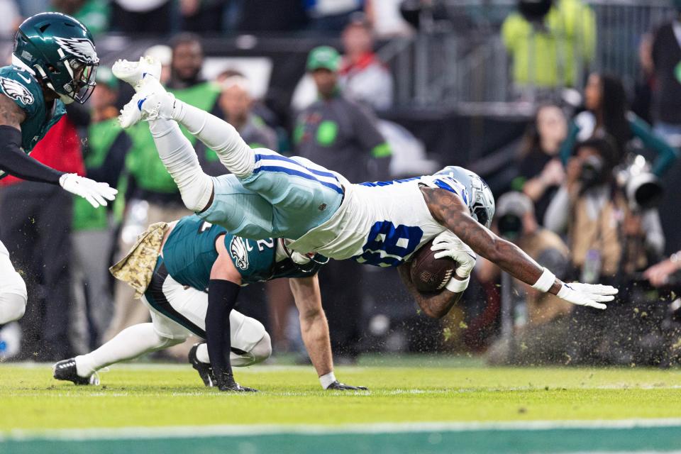 Cowboys wide receiver CeeDee Lamb dives with the ball after a catch past Eagles safety Reed Blankenship during the first quarter at Lincoln Financial Field in Philadelphia on Nov. 5, 2023.