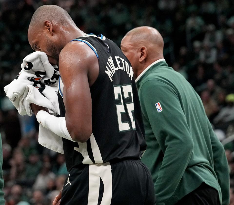 Milwaukee Bucks forward Khris Middleton walks off the court with head coach Doc Rovers, right, after taking a shot to the mouth during the first half against the Knicks on Sunday night at Fiserv Forum.