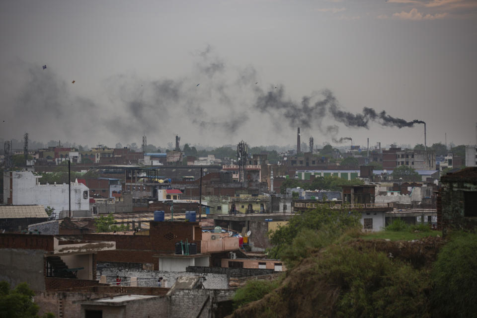 Smoke rises from chimneys of leather tanneries in Kanpur, an industrial city on the banks of the river Ganges, India, Tuesday, June 23, 2020. Kanpur city produces an estimated 450 million liters of municipal sewage and industrial effluent daily, much of which flowed directly into the Ganges until recently. Today that number is lower, though it's not clear by how much, after a Ganges cleanup project closed some drains and diverted industrial pollution to treatment plants. (AP Photo/Altaf Qadri)