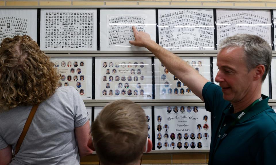 Gesu School principal Brian O'Rourke points out to Eric Hansknecht, 69, his class of 1969 picture during a tour of the old school during the 100-year celebration at Gesu Catholic Church and School in Detroit on Saturday, July 30, 2022.