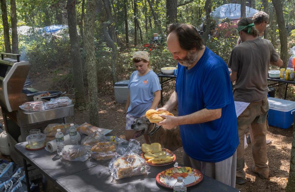 Residents of a homeless camp in Toms River share a mid-day Friday afternoon meal. Although the normally eat separately a communal meal happens a few times a month.