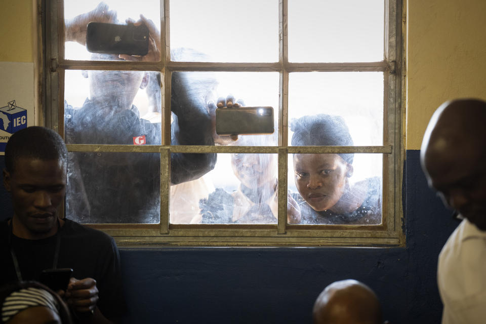 People watch as former president of the A.N.C. and South Africa Jacob Zuma, casts his ballot on Wednesday May 29, 2024 during general elections in Nkandla, Kwazulu Natal, South Africa. South Africans are voting in an election seen as their country's most important in 30 years, and one that could put them in unknown territory in the short history of their democracy, the three-decade dominance of the African National Congress party being the target of a new generation of discontent in a country of 62 million people — half of whom are estimated to be living in poverty. (AP Photo/Emilio Morenatti)