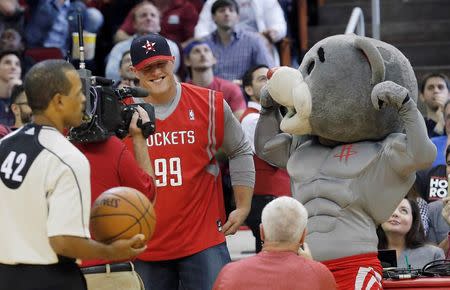 Nov 2, 2015; Houston, TX, USA; Houston Rockets mascot Clutch gives Houston Texans player JJ Watt a Rocket shirt during an Oklahoma City Thunder timeout in the fourth quarter at Toyota Center. Rocket won 110 to 105. Mandatory Credit: Thomas B. Shea-USA TODAY Sports